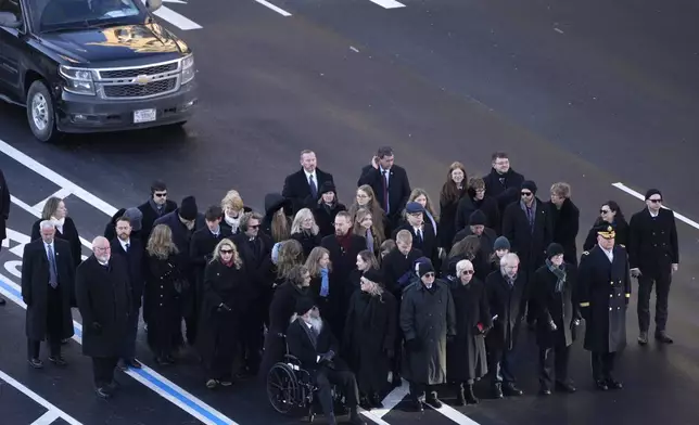 Members of the Carter family look on as the flag-draped casket of former President Jimmy Carter is transferred to a horse-drawn caisson at the U.S. Navy Memorial before traveling on to the Capitol in Washington, Tuesday, Jan. 7, 2025, where Carter will lie in state. Carter died Dec. 29 at the age of 100. (AP Photo/Mark Schiefelbein, Pool)