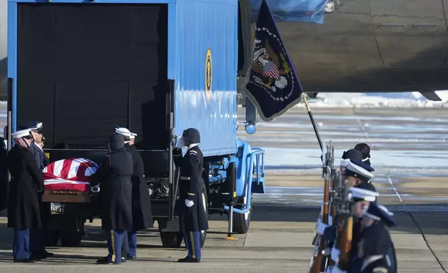 A joint services military body bearer team prepares to carry the flag-draped casket of former President Jimmy Carter on arrival at Joint Base Andrews, Md., Tuesday, Jan. 7, 2025, and will travel to the Capitol where he will lie in State. Carter died Dec. 29 at the age of 100. (AP Photo/Steve Helber)