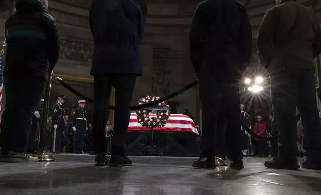 Mourners look at the flag-draped casket of former President Jimmy Carter as he lies in state in the Capitol, Tuesday, Jan. 7, 2025, in Washington. (AP Photo/Jose Luis Magana)