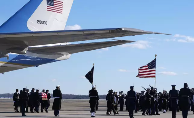 A joint forces body bearer team moves the flag-draped casket of former President Jimmy Carter upon arrival at Joint Base Andrews, Md., Tuesday, Jan. 7, 2025. Carter died Dec. 29, at the age of 100. (AP Photo/Susan Walsh, Pool)