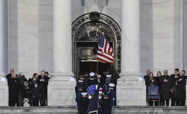 Members of the Carter family look on as a joint services military body bearer team carries the flag-draped casket of former President Jimmy Carter up the steps into the U.S Capitol, Tuesday, Jan. 7, 2025, in Washington. Carter died Dec. 29 at the age of 100. (Jemal Countess/Pool via AP)