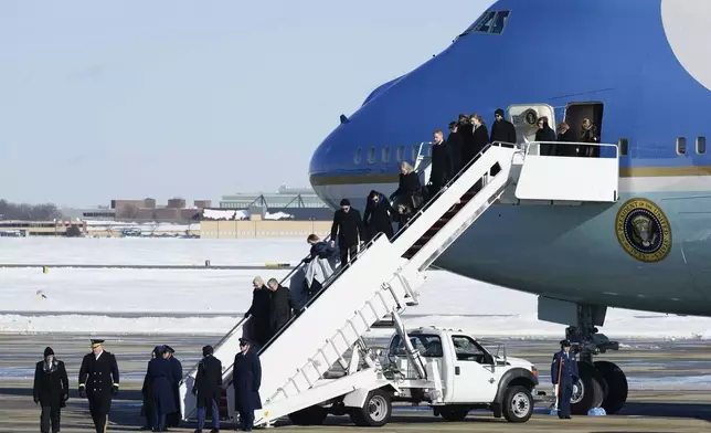 Carter family and others, walk off a military plane carrying the casket of former President Jimmy Carter, as they arrive at Joint Base Andrews, Md., Tuesday, Jan. 7, 2025. (AP Photo/Steve Helber)