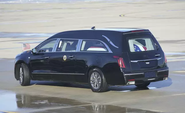 A hearse carrying the flag-draped casket of former President Jimmy Carter departs Joint Base Andrews, Md., following his arrival, Tuesday, Jan. 7, 2025, and will travel to the Capitol where he will lie in State. Carter died Dec. 29 at the age of 100. (AP Photo/Steve Helber)