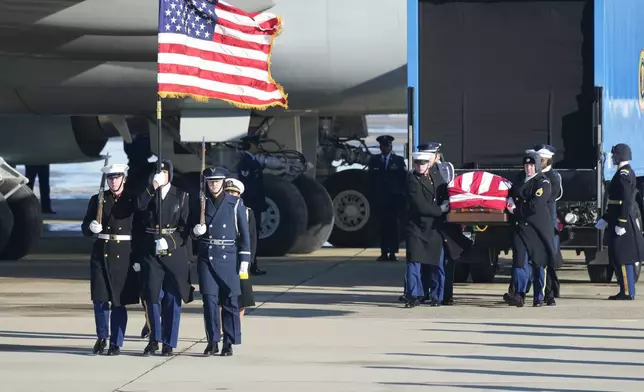 A joint services military body bearer team prepares to carries the flag-draped casket of former President Jimmy Carter on arrival at Joint Base Andrews, Md., Tuesday, Jan. 7, 2025, and will travel on to the Capitol where he will lie in State. Carter died Dec. 29 at the age of 100. (AP Photo/Steve Helber)