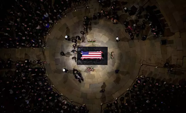 A family member touches the flag-draped casket of former President Jimmy Carter lies in state at the rotunda of the U.S. Capitol Tuesday, Jan. 7, 2025, in Washington. (Andrew Harnik/Pool via AP)