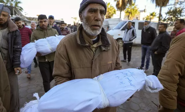 Abdallah Abu Libda carries the body of his 6-month-old nephew, Mohammad Abu Libda, as victims of overnight Israeli army strikes at multiple locations in the central Gaza Strip are prepared for funeral prayers at Al-Aqsa Martyrs Hospital in Deir al-Balah, on Friday, Jan. 3, 2025. According to Al-Aqsa Martyrs Hospital, 30 people, including 10 women and 7 children, were killed in the attacks. (AP Photo/Abdel Kareem Hana)