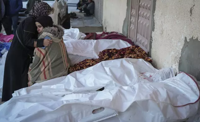 Relatives mourn over the bodies of victims of overnight Israeli army strikes at multiple locations in central Gaza Strip, at Al-Aqsa Martyrs Hospital in Deir al-Balah, Friday, Jan. 3, 2025. According to Al-Aqsa Martyrs Hospital, 30 people, including 10 women and 7 children, were killed in several attacks overnight in central Gaza. (AP Photo/Abdel Kareem Hana)