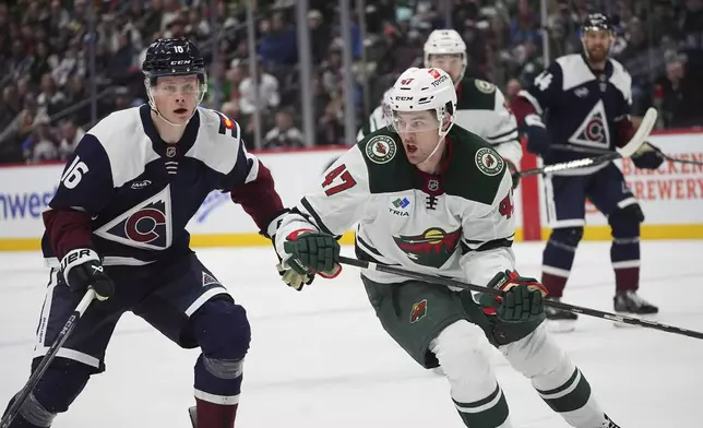 Minnesota Wild defenseman Declan Chisholm, right, pursues the puck with Colorado Avalanche center Juuso Parssinen in the first period of an NHL hockey game Monday, Jan. 20, 2025, in Denver. (AP Photo/David Zalubowski)