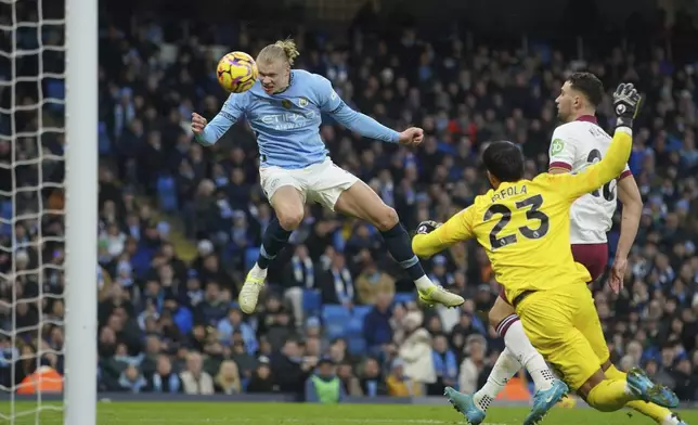 Manchester City's Erling Haaland, left, scores his side's second goal against West Ham during a English Premier League soccer match at Etihad stadium in Manchester, England, Saturday, Jan. 4, 2025. (AP Photo/Ian Hodgson)