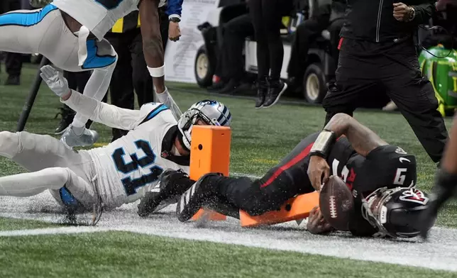 Atlanta Falcons quarterback Michael Penix Jr. scores past Carolina Panthers cornerback Caleb Farley during the first half of an NFL football game, Sunday, Jan. 5, 2025, in Atlanta. (AP Photo/Mike Stewart)