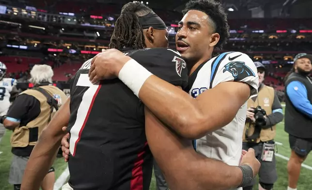 Carolina Panthers quarterback Bryce Young and Atlanta Falcons running back Bijan Robinson hug after overtime in an NFL football game, Sunday, Jan. 5, 2025, in Atlanta. (AP Photo/Brynn Anderson)