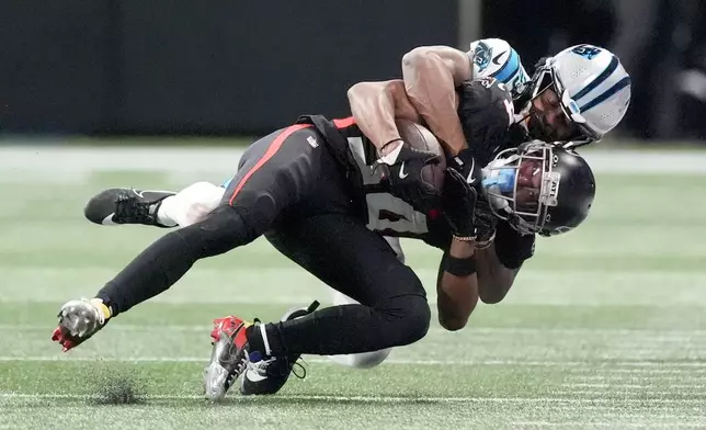 Atlanta Falcons cornerback A.J. Terrell is tackled by Carolina Panthers cornerback Akayleb Evans during the first half of an NFL football game, Sunday, Jan. 5, 2025, in Atlanta. (AP Photo/Mike Stewart)