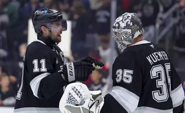 Los Angeles Kings center Anze Kopitar, left, celebrates with goaltender Darcy Kuemper after the team's win against the New Jersey Devils during an NHL hockey game, Wednesday, Jan. 1, 2025, in Los Angeles. (AP Photo/Ryan Sun)