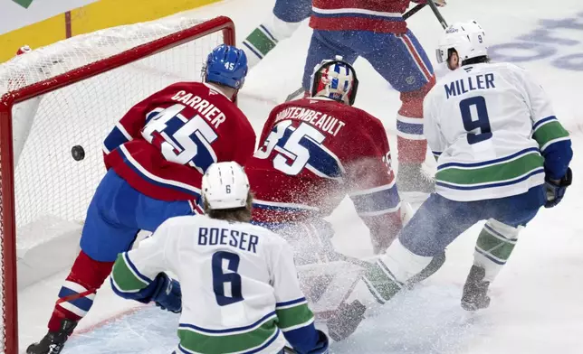 Vancouver Canucks center J.T. Miller (9) scores the second goal against Montreal Canadiens goaltender Sam Montembeault (35) during second-period NHL hockey game action in Montreal, Monday, Jan. 6, 2025. (Ryan Remiorz/The Canadian Press via AP) n Press via AP)