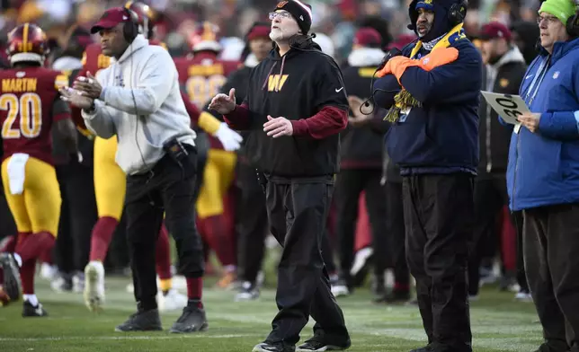 Washington Commanders head coach Dan Quinn, center, on the sidelines during the second half of an NFL football game against the Philadelphia Eagles, Sunday, Dec. 22, 2024, in Landover, Md. (AP Photo/Nick Wass)