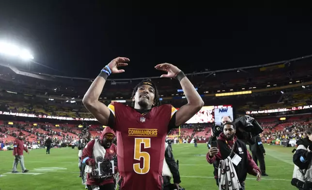 Washington Commanders quarterback Jayden Daniels (5) waves to the crowd after an overtime victory over the Atlanta Falcons during an NFL football game, Sunday, Dec. 29, 2024, in Landover, Md. The Commanders won 30-24. (AP Photo/Nick Wass)