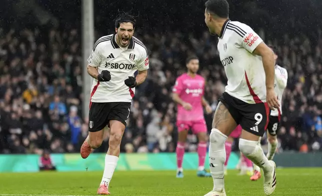 Fulham's Raul Jimenez, left, celebrates after scoring his sides first goal from the penalty spot during the English Premier League soccer match between Fulham and Ipswich Town at Craven Cottage stadium, London, Sunday Jan. 5, 2025. (Andrew Matthews/PA via AP)