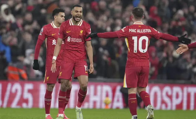 Liverpool's Cody Gakpo, left, celebrates after scoring his side's first goal against Manchester United during the English Premier League soccer match at the Anfield stadium in Liverpool, England, Sunday, Jan. 5, 2025. (AP Photo/Jon Super)