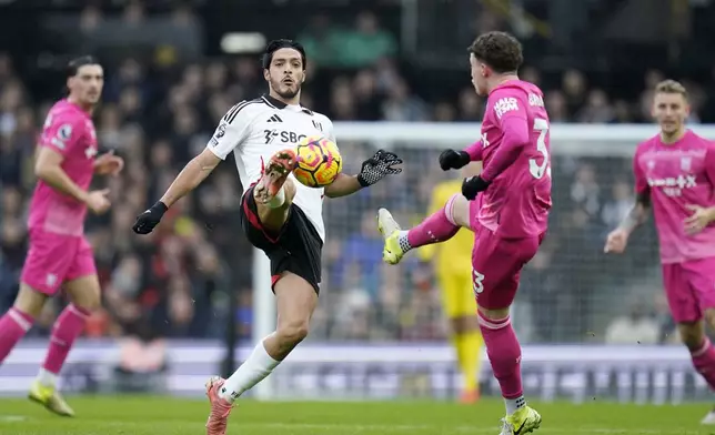 Fulham's Raul Jimenez, left, and Ipswich Town's Nathan Broadhead fight for the ball during the English Premier League soccer match between Fulham and Ipswich Town at Craven Cottage stadium, London, Sunday Jan. 5, 2025. (Andrew Matthews/PA via AP)