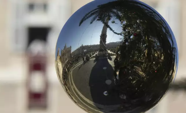 A Christmas tree decoration reflects St. Peter's Square at The Vatican when Pope Francis appeared at his studio's window overlooking the square to bless pilgrims and faithful after presiding over a mass in St. Peter's Basilica on New Year's Day, Wednesday, Jan. 1, 2025. (AP Photo/Andrew Medichini)