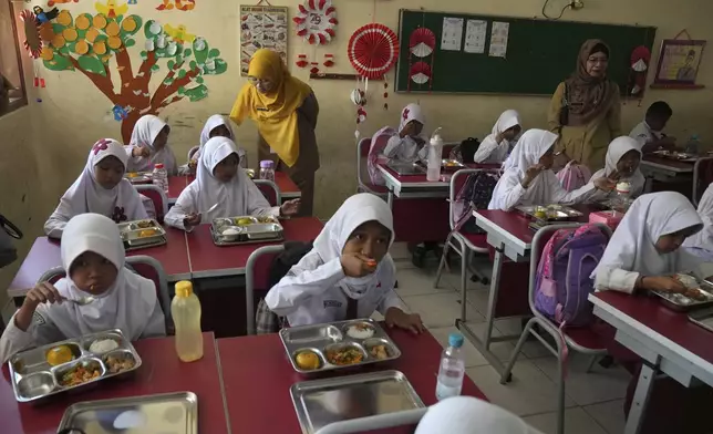 Students have their meals during the kick off of President Prabowo Subianto's ambitious free meal program to feed children and pregnant women nationwide despite critics saying that its required logistics could hurt Indonesia's state finances and economy, at an elementary school in Depok, West Java, Indonesia, Monday, Jan. 6, 2025. (AP Photo/Dita Alangkara)