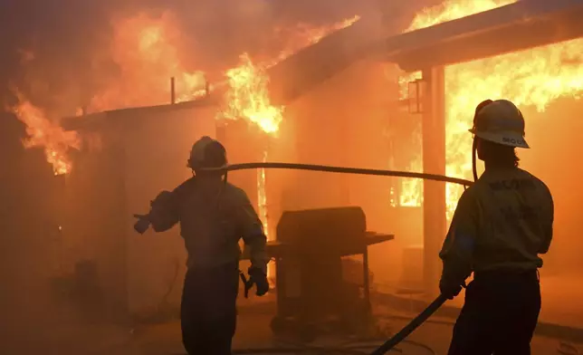 Firefighters battle the Eaton Fire as it engulfs structures Wednesday, Jan. 8, 2025 in Altadena, Calif. (AP Photo/Nic Coury)