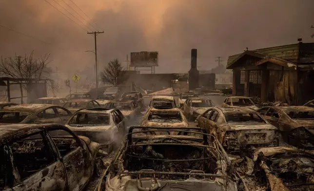 Fire-damaged vehicles are lined up at a dealership after the Eaton Fire swept through Wednesday, Jan. 8, 2025 in Altadena, Calif. (AP Photo/Ethan Swope)