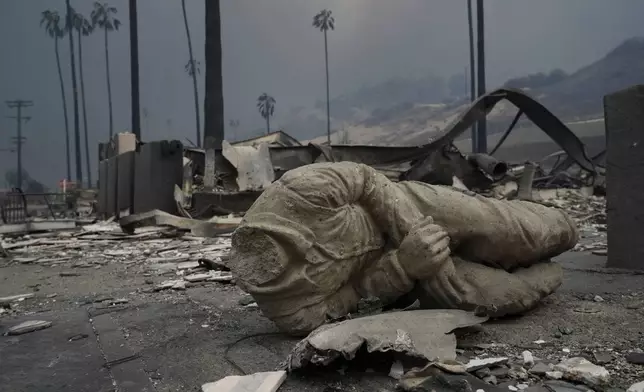 A statue and other structures are burned as the Palisades Fire ravages a neighborhood amid high winds in the Pacific Palisades neighborhood of Los Angeles, Wednesday, Jan. 8, 2025. (AP Photo/Damian Dovarganes)