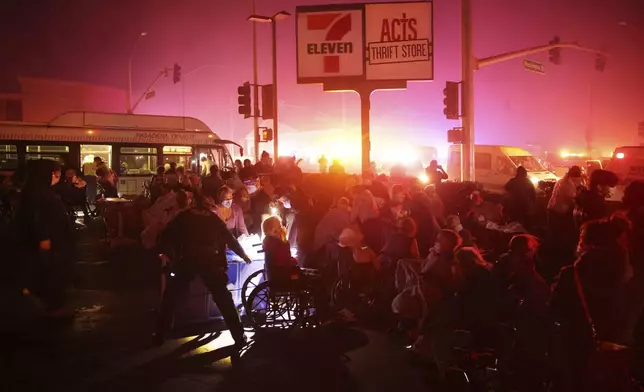 Residents of a senior center are evacuated as the Eaton Fire approaches Tuesday, Jan. 7, 2025, in Altadena, Calif. (AP Photo/Ethan Swope)