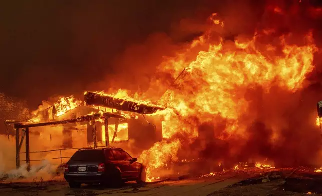 The Eaton Fire engulfs a property Wednesday, Jan. 8, 2025 in Altadena, Calif. (AP Photo/Ethan Swope)