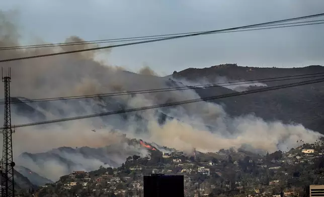 Small fires are seen along a hillside burn the Brentwood section of Los Angeles on Wednesday, Jan. 8, 2025. (AP Photo/Richard Vogel)