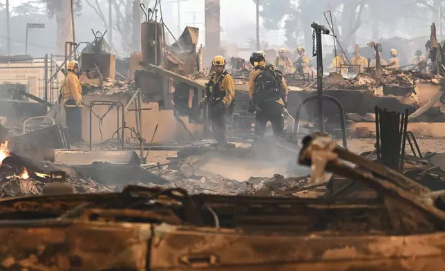 Firefighters work inside a burned structure while battling the Eaton Fire, Wednesday, Jan. 8, 2025, in Altadena, Calif. (AP Photo/Nic Coury)