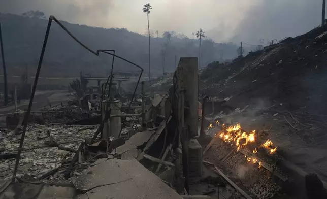 The Palisades Fire ravages a neighborhood amid high winds in the Pacific Palisades neighborhood of Los Angeles, Wednesday, Jan. 8, 2025. (AP Photo/Damian Dovarganes)