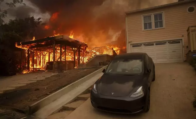 The Palisades Fire burns a structure in the Pacific Palisades neighborhood of Los Angeles, Wednesday, Jan. 8, 2025. (AP Photo/Etienne Laurent)