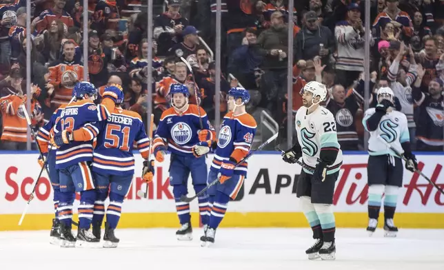 Seattle Kraken's Oliver Bjorkstrand (22) skates past as the Edmonton Oilers celebrate after a goal during first-period NHL hockey game action in Edmonton, Alberta, Monday, Jan. 27, 2025. (Jason Franson/The Canadian Press via AP)