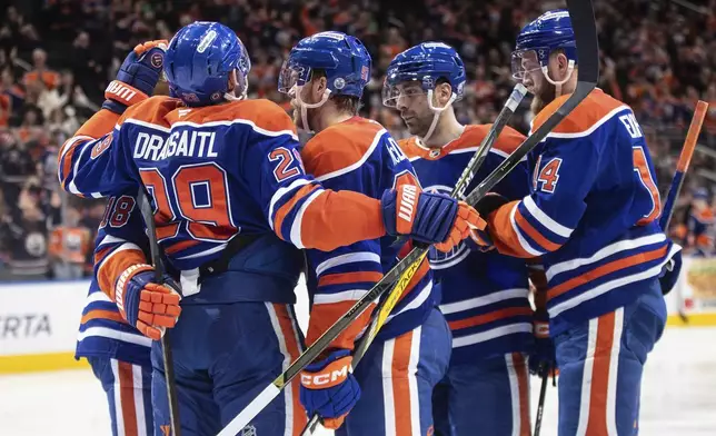 From left to right, Edmonton Oilers' Zach Hyman, Leon Draisaitl, Connor McDavid, Evan Bouchard and Mattias Ekholm celebrate after a goal against the Seattle Kraken during second-period NHL hockey game action in Edmonton, Alberta, Monday, Jan. 27, 2025. (Jason Franson/The Canadian Press via AP)