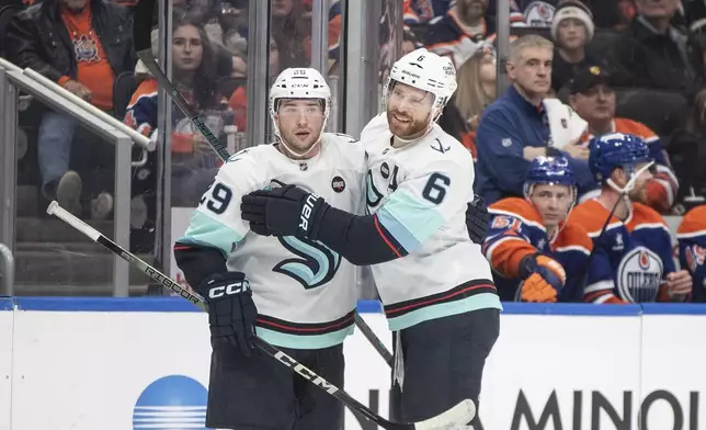 Seattle Kraken's Vince Dunn (29) celebrates after his goal with teammate Adam Larsson (6) during first-period NHL hockey game action against the Edmonton Oilers in Edmonton, Alberta, Monday, Jan. 27, 2025. (Jason Franson/The Canadian Press via AP)