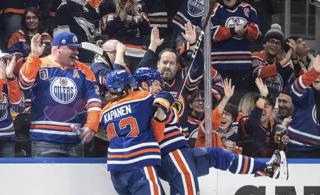 Edmonton Oilers' Kasperi Kapanen (42) and Corey Perry (90) celebrate after Perry's goal against the Seattle Kraken during second-period NHL hockey game action in Edmonton, Alberta, Monday, Jan. 27, 2025. (Jason Franson/The Canadian Press via AP)