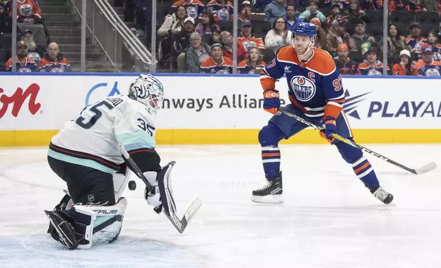 Seattle Kraken goalie Joey Daccord (35) is scored against by Edmonton Oilers' Connor McDavid (97) during second-period NHL hockey game action in Edmonton, Alberta, Monday, Jan. 27, 2025. (Jason Franson/The Canadian Press via AP)