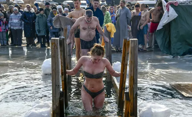 People plunge in icy water to celebrate the Orthodox Epiphany near the St. Serafimovsky Monastery on Russian Island in Russian far east port Vladivostok, Russia, Sunday, Jan. 19, 2025. (AP Photo)