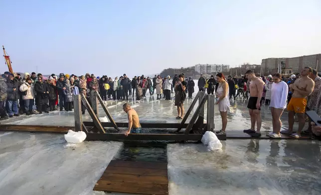 People plunge in icy water to celebrate the Orthodox Epiphany near the St. Serafimovsky Monastery on Russian Island in Russian far east port Vladivostok, Russia, Sunday, Jan. 19, 2025. (AP Photo)
