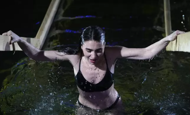 A woman pauses while plunging herself in icy waters to celebrate the Orthodox Epiphany at the Izmailovsky Kremlin in Moscow, Russia, Saturday, Jan. 18, 2025. (AP Photo/Pavel Bednyakov)