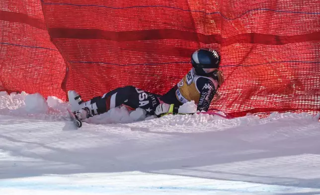 United States' Lindsey Vonn lies on the snow after crashing during an alpine ski, women's World Cup downhill training, in Cortina d'Ampezzo, Italy, Thursday, Jan. 16, 2025. (AP Photo/Marco Trovati)