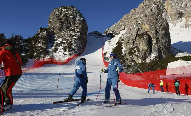 United States' Lindsey Vonn, center right, inspects the course ahead of an alpine ski, women's World Cup downhill training, in Cortina d'Ampezzo, Italy, Thursday, Jan. 16, 2025. (AP Photo/Alessandro Trovati)
