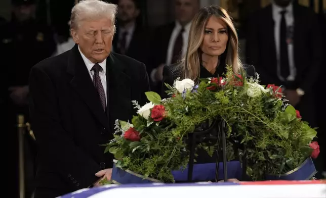 President-elect Donald Trump and Melania Trump pause at the flag-draped casket of former President Jimmy Carter as he lies in state in the rotunda of the U.S. Capitol in Washington, Wednesday, Jan. 8, 2025. (AP Photo/J. Scott Applewhite)