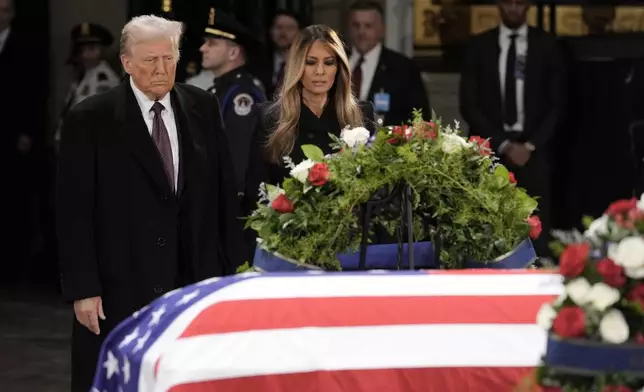 President-elect Donald Trump and Melania Trump pause at the flag-draped casket of former President Jimmy Carter as he lies in state in the rotunda of the U.S. Capitol in Washington, Wednesday, Jan. 8, 2025. (AP Photo/J. Scott Applewhite)