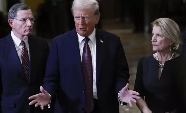 President-elect Donald Trump, flanked by Sen. John Barrasso, R-Wyo., left, Sen. Shelley Moore Capito, R-W.Va., right, talks to reporters after a meeting with Republican leadership at the Capitol on Wednesday, Jan. 8, 2025, in Washington. (AP Photo/Steve Helber)