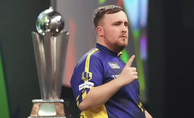 Luke Littler of England celebrates during the final against Michael van Gerwen of the Netherlands at the World Darts Championship at Alexandra Palace in London, Friday, Jan. 3, 2025. (AP Photo/Kirsty Wigglesworth)