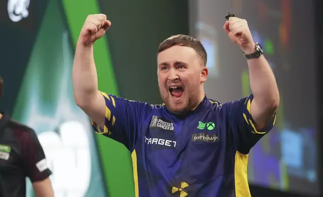 Luke Littler of England celebrates after winning the final against Michael van Gerwen of the Netherlands at the World Darts Championship at Alexandra Palace in London, Friday, Jan. 3, 2025. (AP Photo/Kirsty Wigglesworth)