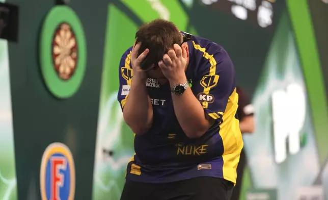 Luke Littler of England celebrates after winning the final against against Michael van Gerwen of the Netherlands at the World Darts Championship at Alexandra Palace in London, Friday, Jan. 3, 2025. (AP Photo/Kirsty Wigglesworth)